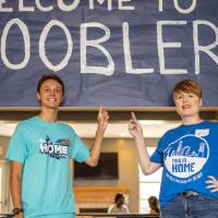 Alumna with RA in front of a sign which reads "Welcome to Hoobler"